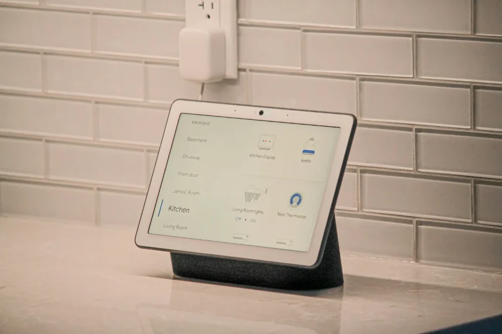 Home automation hub sitting on a kitchen benchtop showing smart device controls for rooms and appliances in a Melbourne home