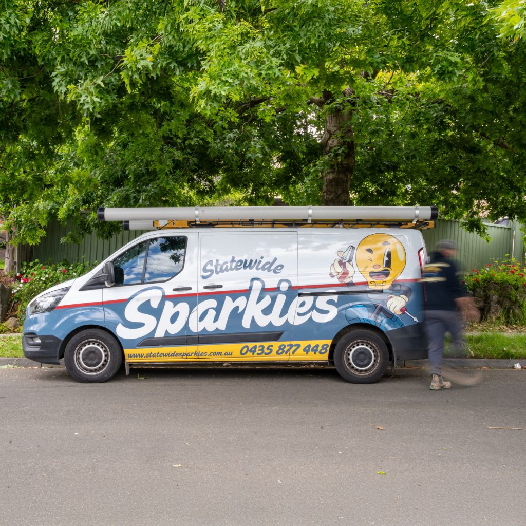 Statewide Sparkies electrician arriving at a job in a branded service van parked on a suburban street
