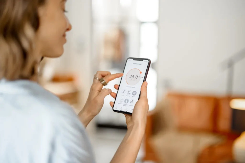 Woman controlling smart home temperature settings via a smartphone app