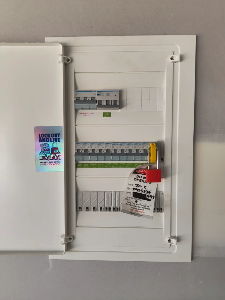 Residential switchboard with circuit breakers fitted with a safety lockout padlock and danger tag during safe isolation by a licensed electrician